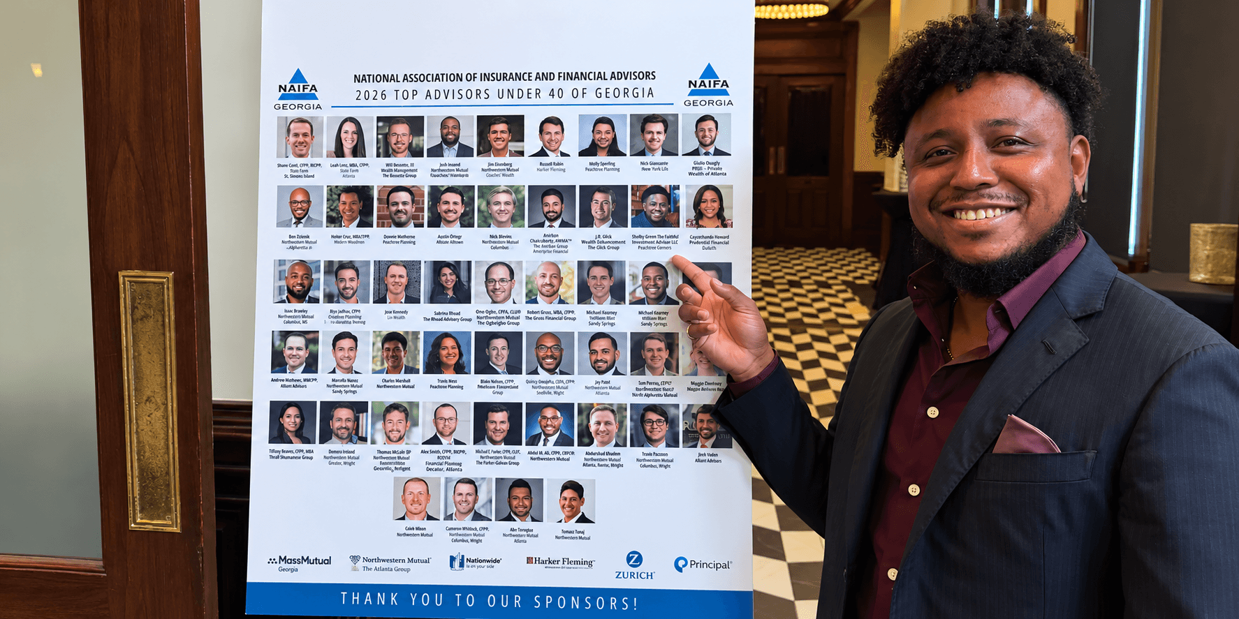 Person smiling while pointing at a poster listing top financial advisors in Georgia