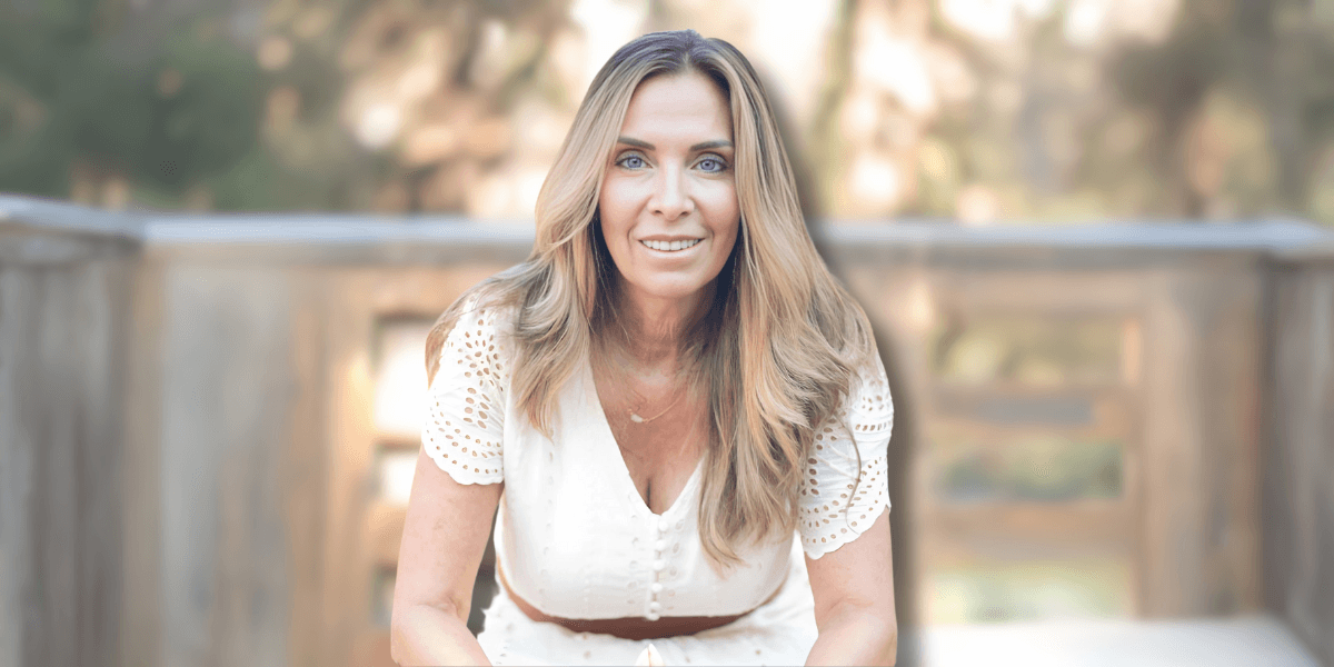 A portrait of Stephanie Rose Vriniotis, a life coach, interior designer, psychic, and artist, smiling outdoors in a white dress.