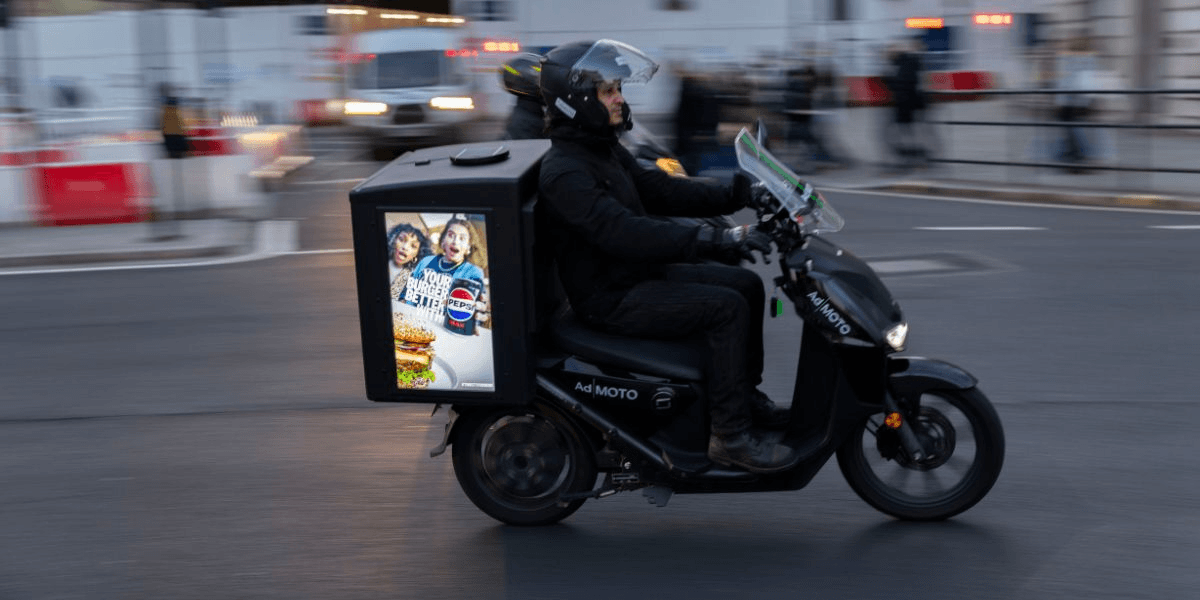 Ad-MOTO electric scooter with digital ad screen revolutionizes outdoor advertising in London’s busy streets.