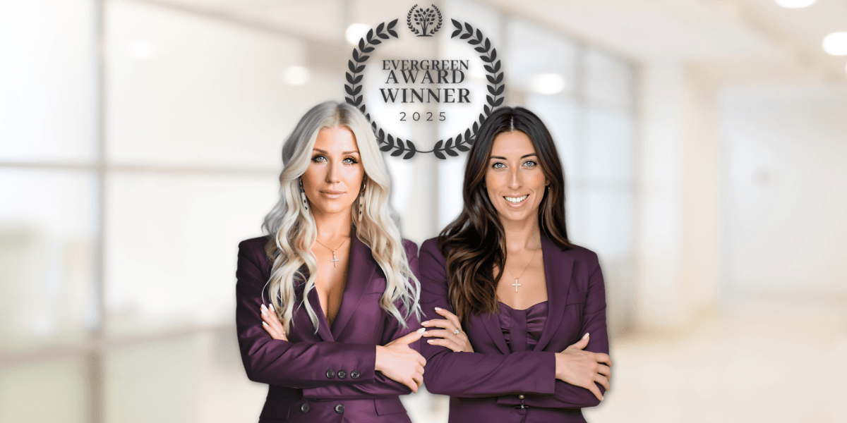 Two women in matching suits pose confidently under "Evergreen Award Winner 2025" emblem, representing Fully Booked AI® success.