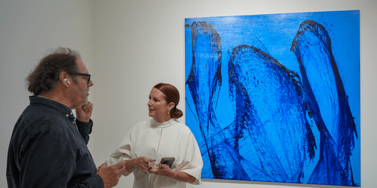 Ritu Raj engaging with guests at an exhibition, showcasing his innovative abstract artwork that blends tradition with modern techniques.