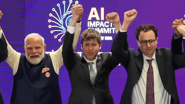 Three individuals raise their arms triumphantly at an AI Impact Summit event