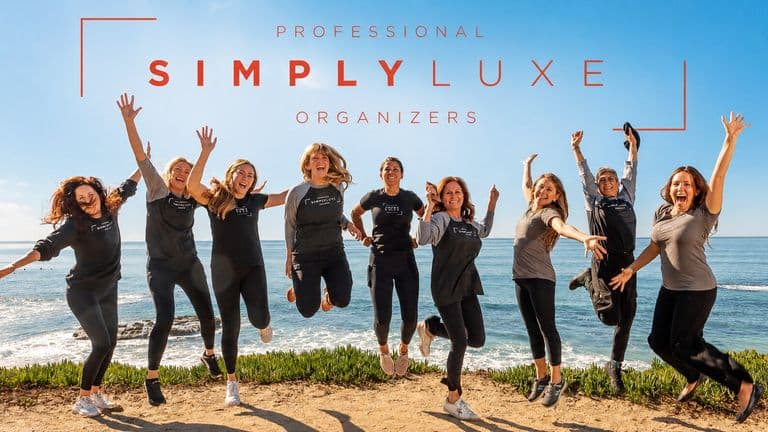 Simply Luxe Organizing team posing together by the ocean beneath the company’s Professional Simply Luxe Organizers branding.