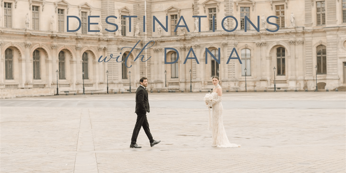 Couple walking in front of a historic building, symbolizing Dana Arnold’s destination wedding photography capturing timeless, emotional moments.