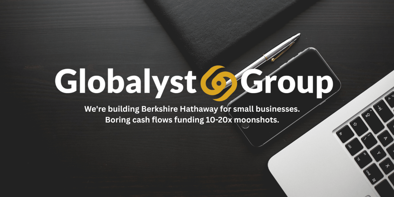Globalyst Group logo on desk with laptop, phone, and pen, representing strategic small business investments.
