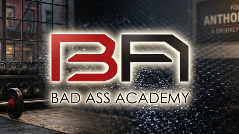 Bad Ass Academy logo inside a Brooklyn functional training gym with kettlebells and a barbell.